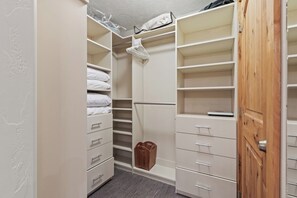 Un dressing avec des étagères ouvertes, des tiroirs et une tringle pour suspendre les vêtements.