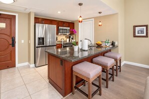 Una cocina con isla central, electrodomésticos de acero inoxidable y armarios de madera.