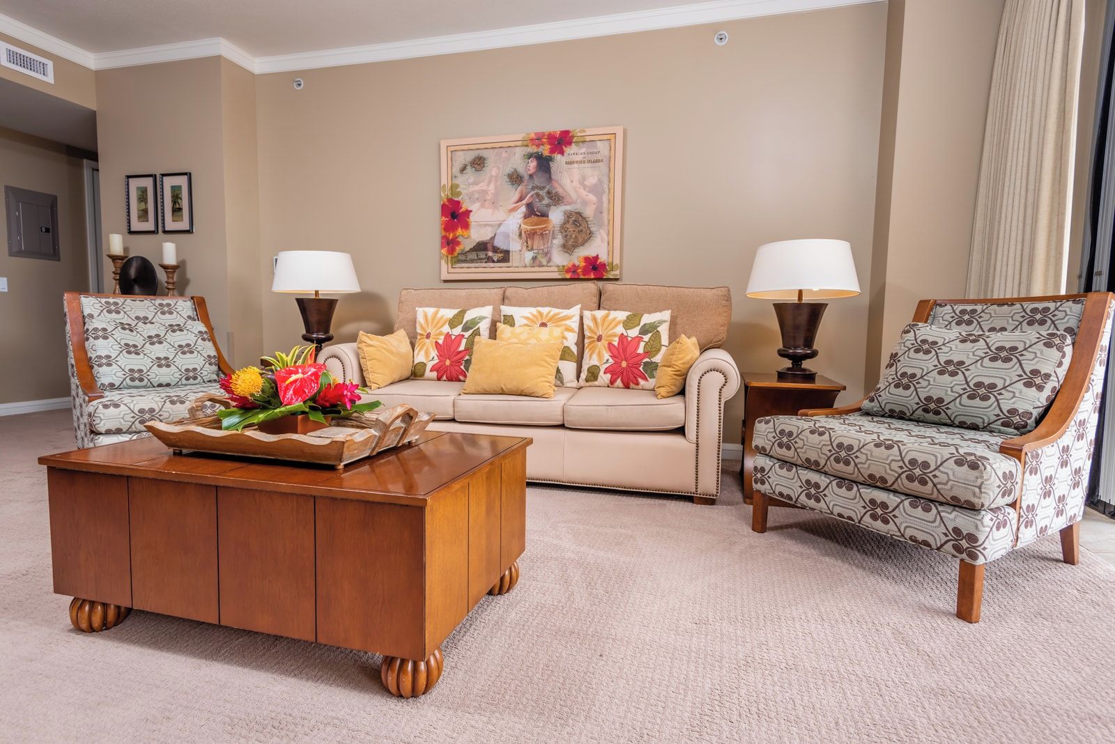 Een woonkamer met een bank, twee fauteuils, een salontafel en een schilderij aan de muur.