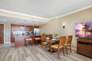 A modern kitchen with wooden cabinets, a central island, and bar stools.