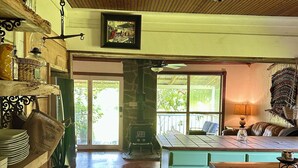 Una cocina rústica con vigas de madera, una chimenea de piedra y vistas al exterior.