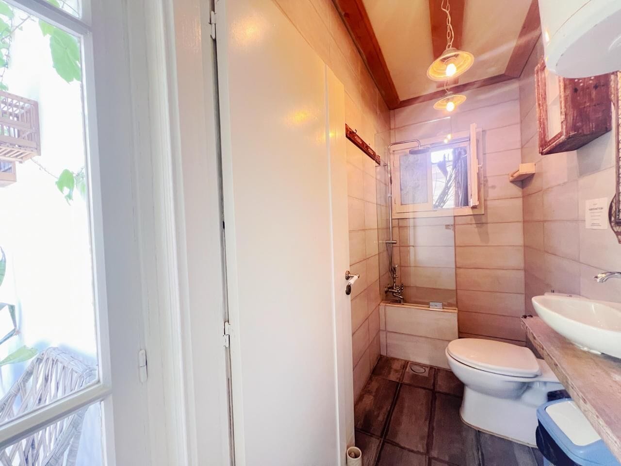 A compact bathroom with a toilet, sink, and shower.