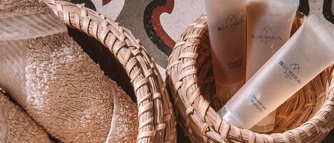 Two wicker baskets with towels and Blue Marlin shampoo bottles on a patterned floor.