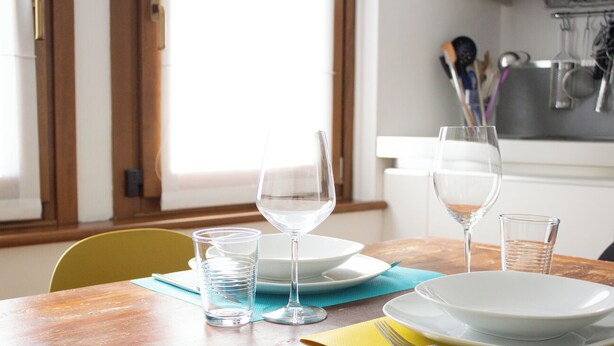 A dining table with plates, glasses, and cutlery. - Passons 4 - One Bedroom Apartment, Sleeps 2 (Udine)