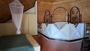 A bedroom with a bed, a mosquito net, and a decorative wall with geometric patterns. - BEAUTIFUL VILLA OPPOSITE THE BEACH AND IN THE CENTER OF SALY (Saly)
