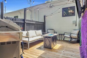An outdoor patio with a grill, seating area, and string lights. - Industrial Loft - Walk to Downtown, Patio w/ BBQ (Spartanburg)