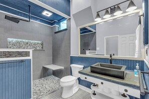 A modern bathroom with a shower, toilet, and vanity. - Walk to Downtown, King Bed, great for long stays (Spartanburg)