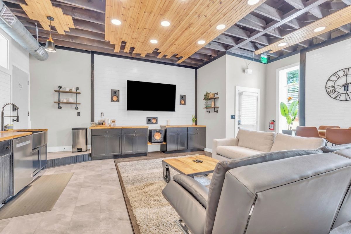 Un interior moderno con cocina, zona de estar y un televisor de pantalla plana grande.
