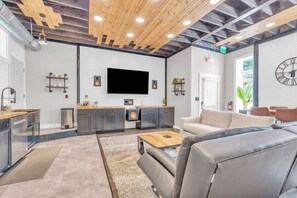 Ein modernes Interieur mit Küche, Sitzgelegenheit und großem Flachbildfernseher.