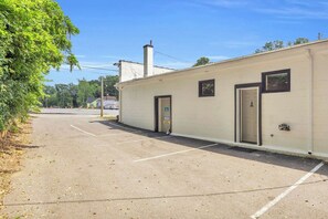 A building with a door marked 'A' and a sign indicating a parking area. - Industrial Loft - Walk to Downtown, Patio w/ BBQ (Spartanburg)