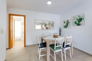 A dining area with a table, chairs, a mirror, and cactus artwork on the wall. - Apartment 'Calma Mar' with Shared Pool, Wi-Fi and Air Conditioning (Los Mártires)