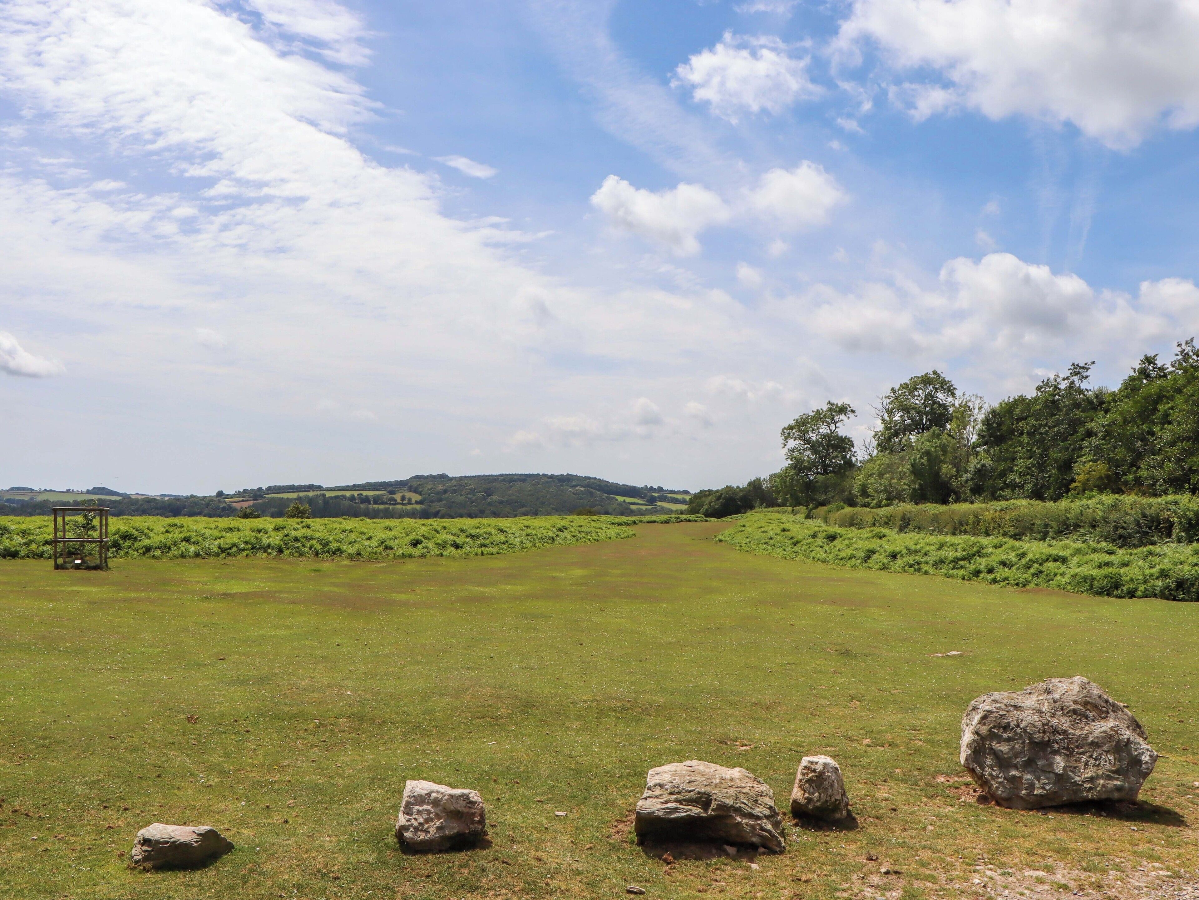 Un campo cubierto de césped con varias rocas grandes y una estructura metálica.
