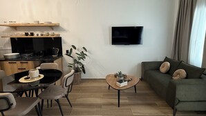 A modern living room with a sofa, coffee table, and dining area.