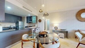 Une cuisine moderne avec des meubles de couleur sombre, un îlot central et des luminaires suspendus.