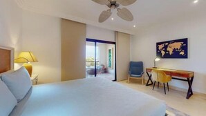 Une chambre d’hôtel avec un lit, un bureau, une chaise et une carte du monde accrochée au mur.
