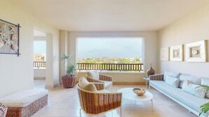 Un salon spacieux avec balcon, des meubles en osier et une vue sur la ville.