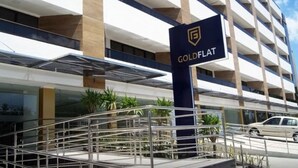 Ein modernes Gebäude, an dem ein Schild mit der Aufschrift 'GOLDFLAT' zu sehen ist.