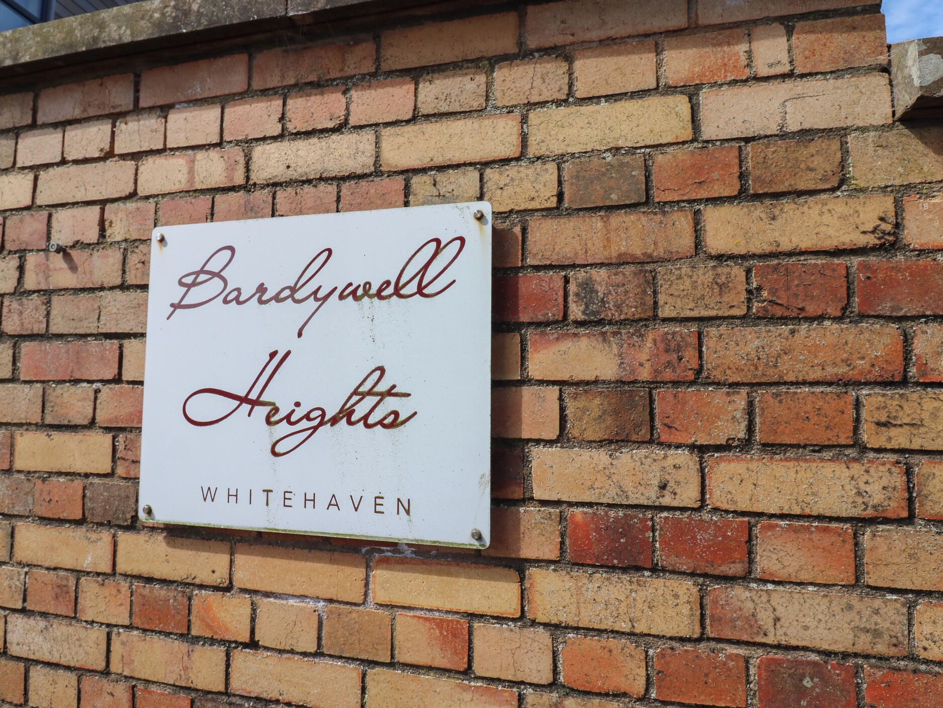 Un cartel en una pared de ladrillo que dice 'Bardywell Heights Whitehaven'.