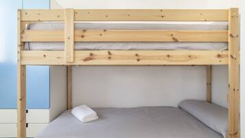 A bunk bed with a grey mattress and a white blanket.