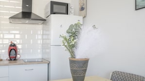 A kitchen with a microwave, a stove, and a potted plant on the counter. - Apartment 'Playa Regla' with Balcony, Wi-Fi and Air Conditioning (Chipiona)