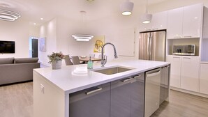 A modern kitchen with a central island, stainless steel appliances, and pendant lighting. - Exquisite condo in lovely Old Montréal with private terrace (Montréal)