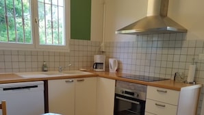 A kitchen with a dishwasher, oven, and a window with bars. - Quiet house near the lake, ideal for families (Sanguinet)