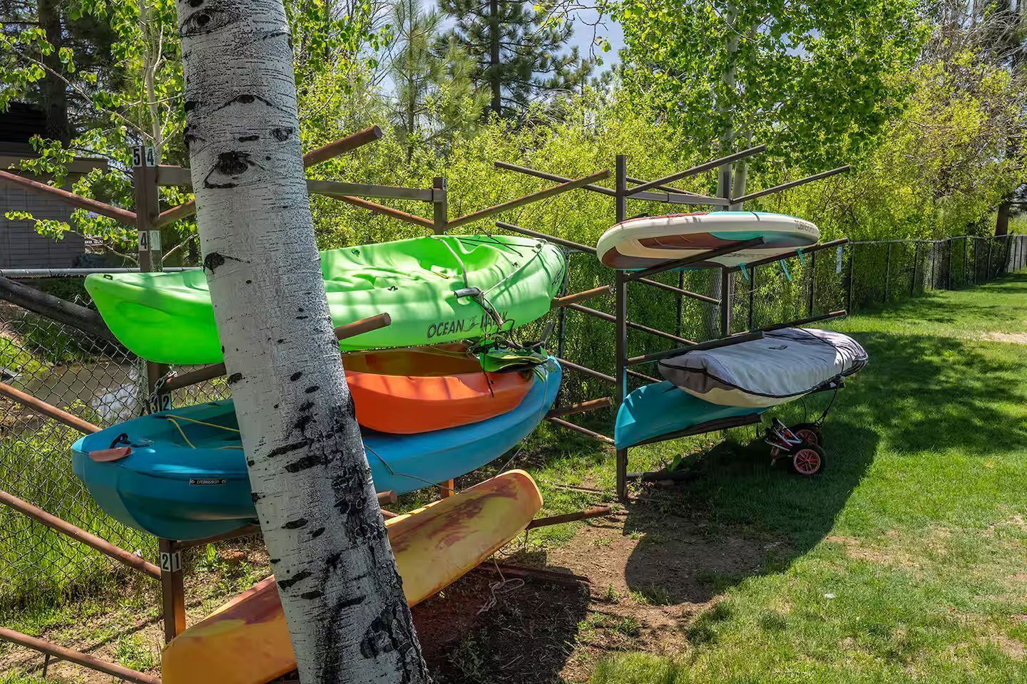 Estación de alquiler de kayaks con varias embarcaciones y una zona de estar cubierta.
