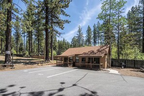A lodge with a porch and a barbecue area, surrounded by tall pine trees. - Cozy ski Studio in woods / 15 min to NorthStar (Tahoe Vista)