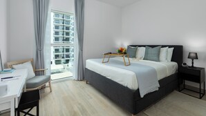 A modern hotel room with a bed, bedside table, desk, and chair. - Maison Privee – Chic Yas Island Escape w/ Iconic Ferrari World Vws (Abu Dhabi)
