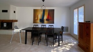 A spacious dining area with a large table and chairs, a modern pendant light, and a large abstract painting on the wall. - Top: Detached Villa for 8 People • Air Conditioning • Terrace • Beaches within a 10-minute walk (Saint-Cyr-sur-Mer)