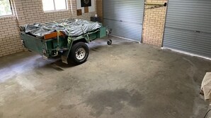 Eine Garage mit einem grünen Dienstfahrzeug darin.