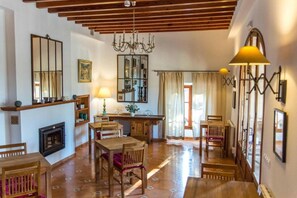 Un amplio salón con chimenea, muebles de madera y un candelabro.