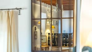 Una habitación con ventana, cortina y candelabro.