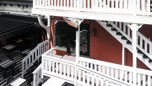 Ein zweistöckiges Gebäude mit Balkon, Treppe und einer Ziegel-Fassade.