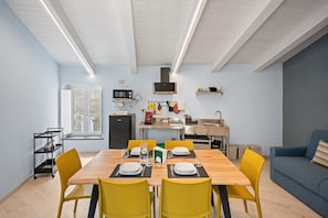 Una cocina moderna con comedor, sofá y ventana.