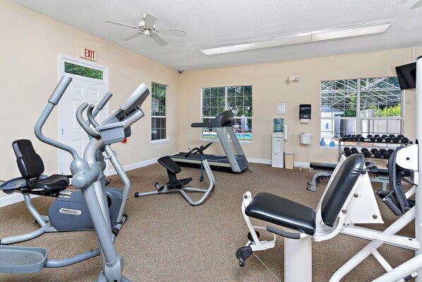 A gym with cardio machines, dumbbells, and a treadmill. - Centrally located condo for 4 with a community swimming pool. (Saint Simons Island)