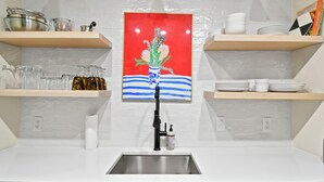 A kitchen with white countertops, a stainless steel sink, and a dish rack. - Centrally located condo for 4 with a community swimming pool. (Saint Simons Island)