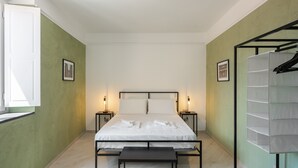 A bedroom with a bed, bedside tables, a bench, a window, and a wall-mounted shelf. - Apartment 'Senofane' with Wi-Fi and Air Conditioning (Ascea)