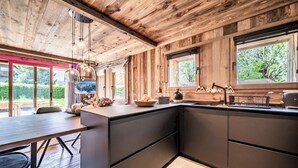 Una cocina moderna con detalles de madera, una isla grande y vista a zonas verdes.