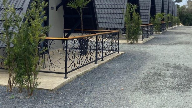 A row of modern, triangular-roofed buildings with outdoor seating areas and small trees. - Hotel Villa Verde by Easy Hotéis (Sao Bento do Sul)