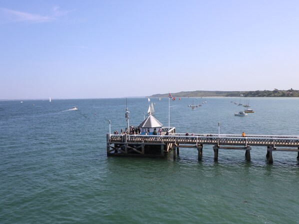 A pier extending into calm waters with several boats and a clear sky. - Vermont 4 (Yarmouth)