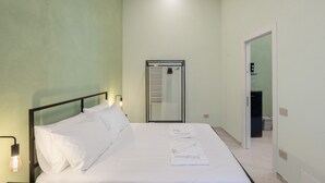 A hotel room with a bed, a mirror, a door, and a light fixture. - Apartment 'Deluxe Melisso' with Wi-Fi and Air Conditioning (Ascea)