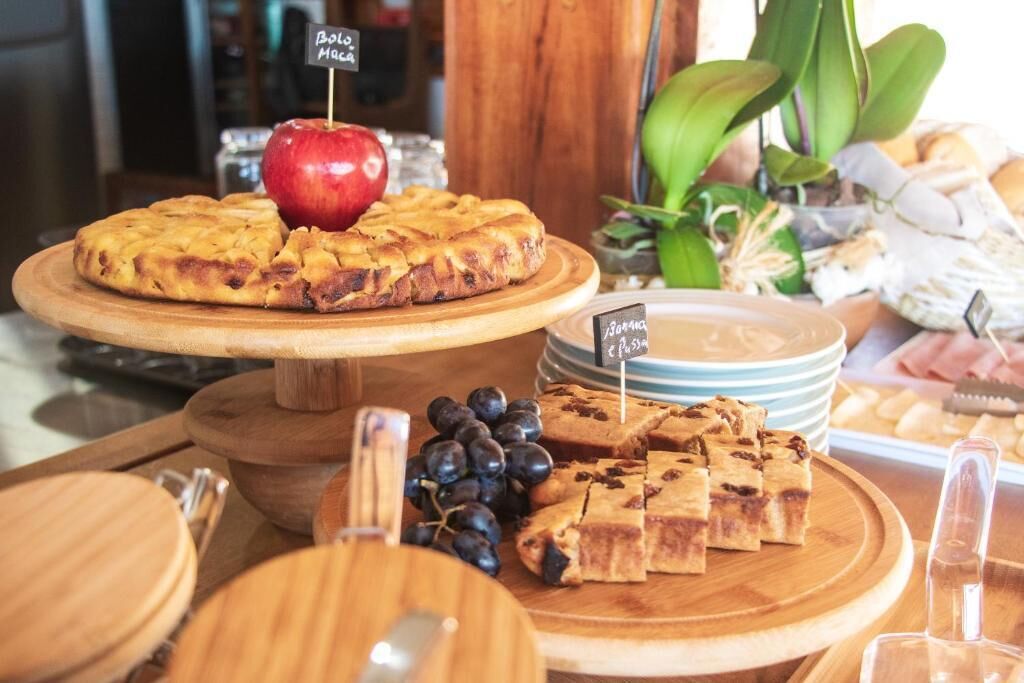A dessert display with various baked goods, including a pie and chocolate squares, on wooden serving boards.