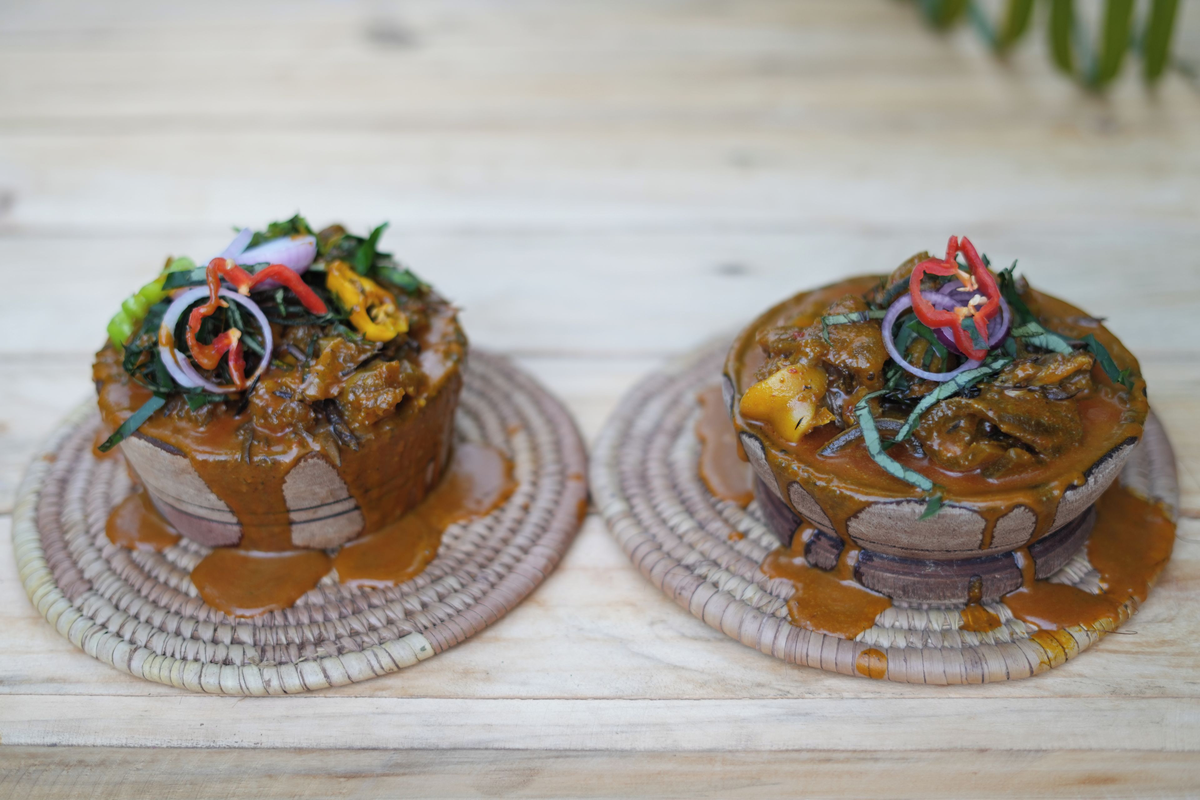 Two dishes on woven mats with a wooden surface underneath.