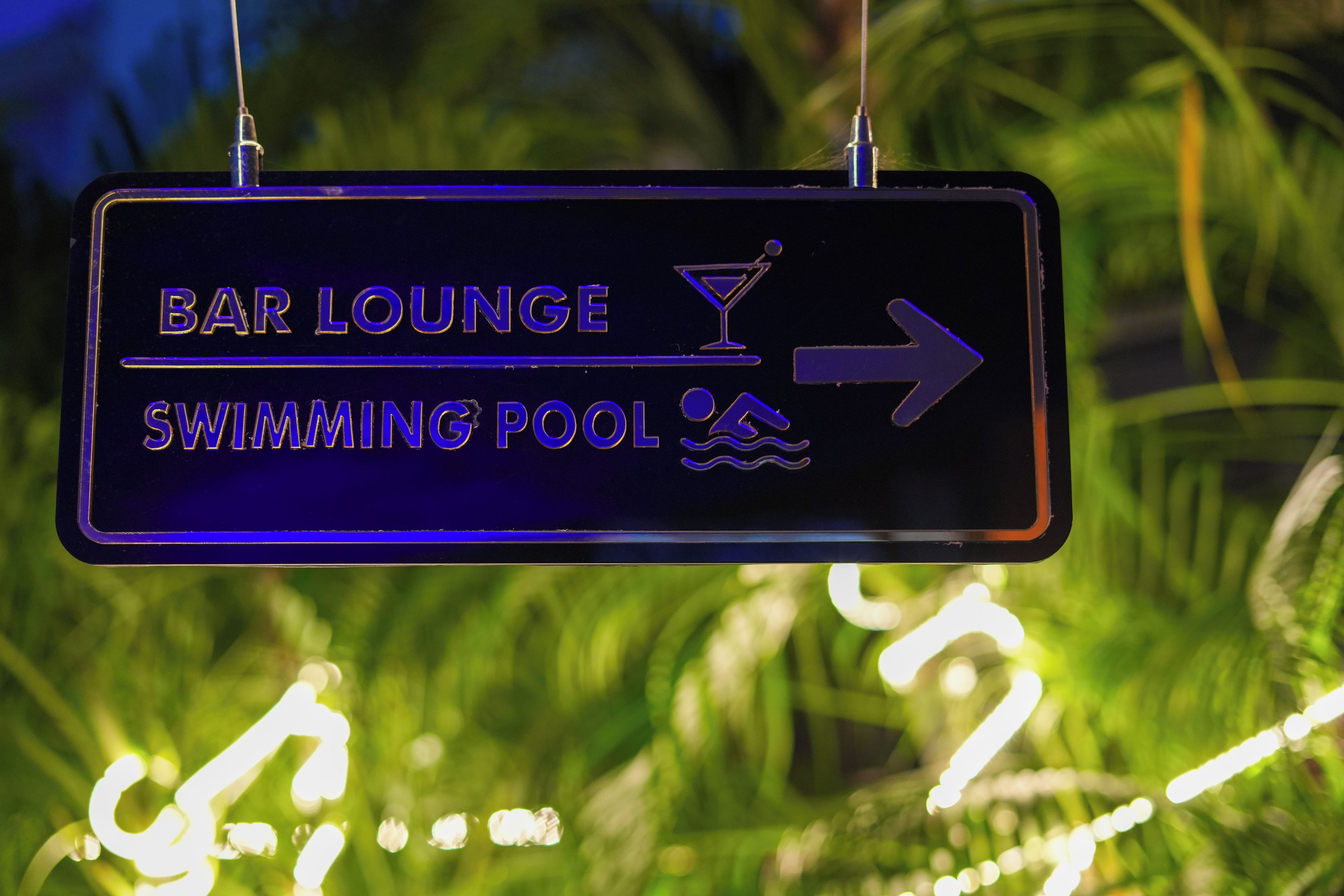 A directional sign for a bar lounge and swimming pool.