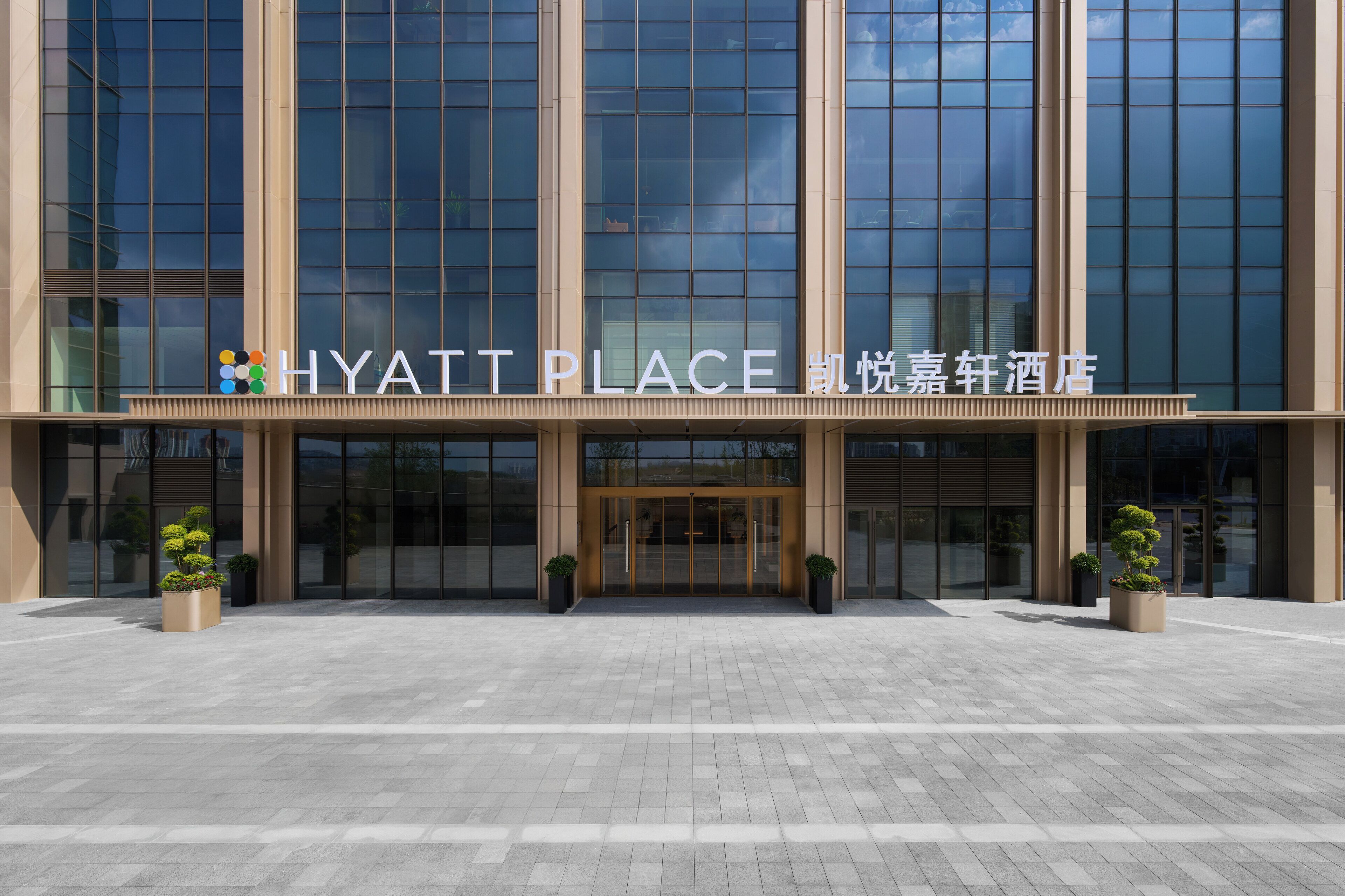A modern building with a glass facade and a sign reading 'HYATT PLACE.'