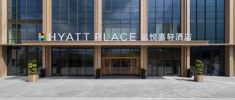 A modern building with a glass facade and a sign reading 'HYATT PLACE.'