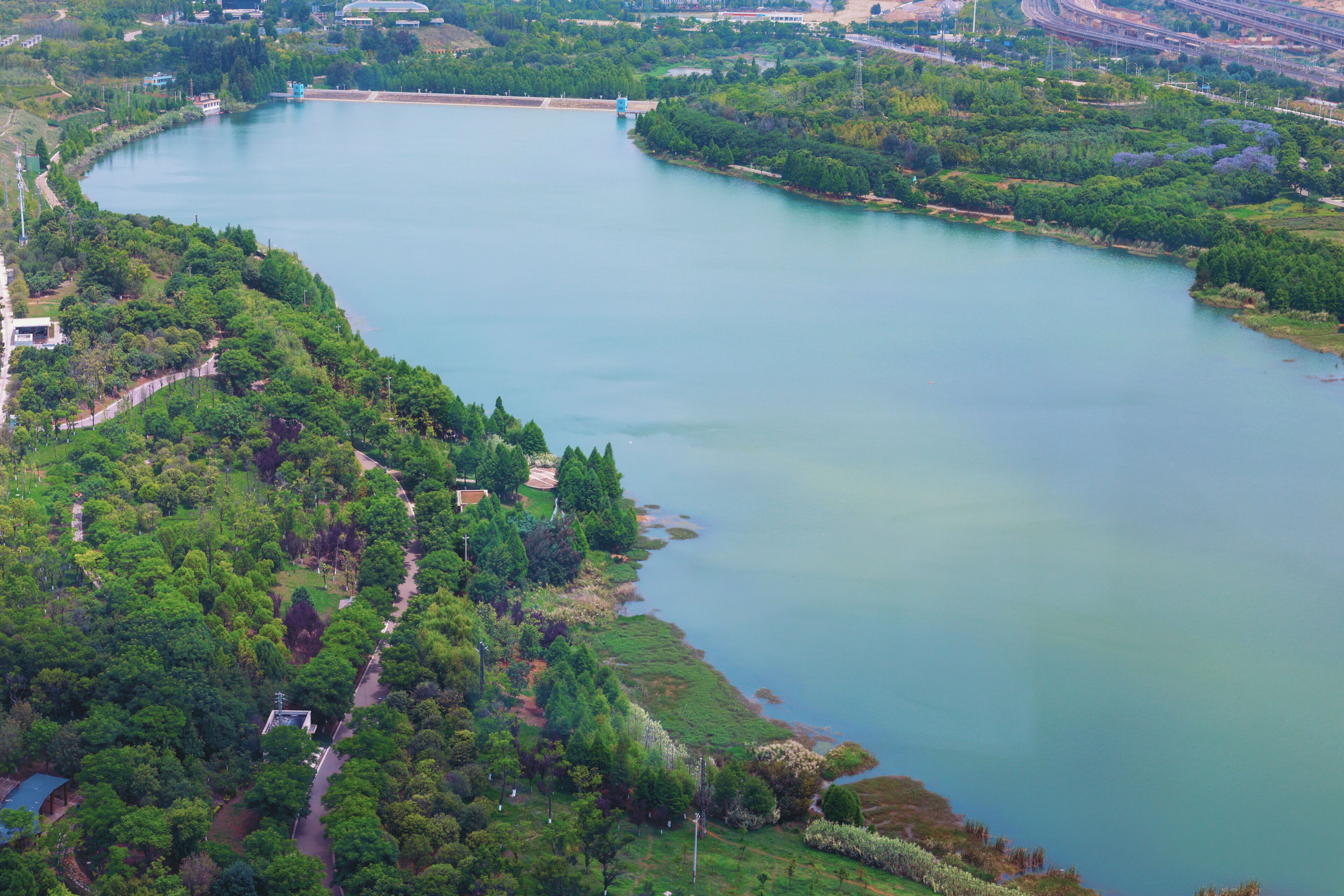 Vue aérienne d’une rivière, de la végétation luxuriante qui l’entoure et de quelques bâtiments situés le long de ses rives.