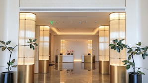 A hotel lobby with a reception desk, potted plants, and a polished floor. - Hyatt Place Kunming South Railway Station (Kunming)
