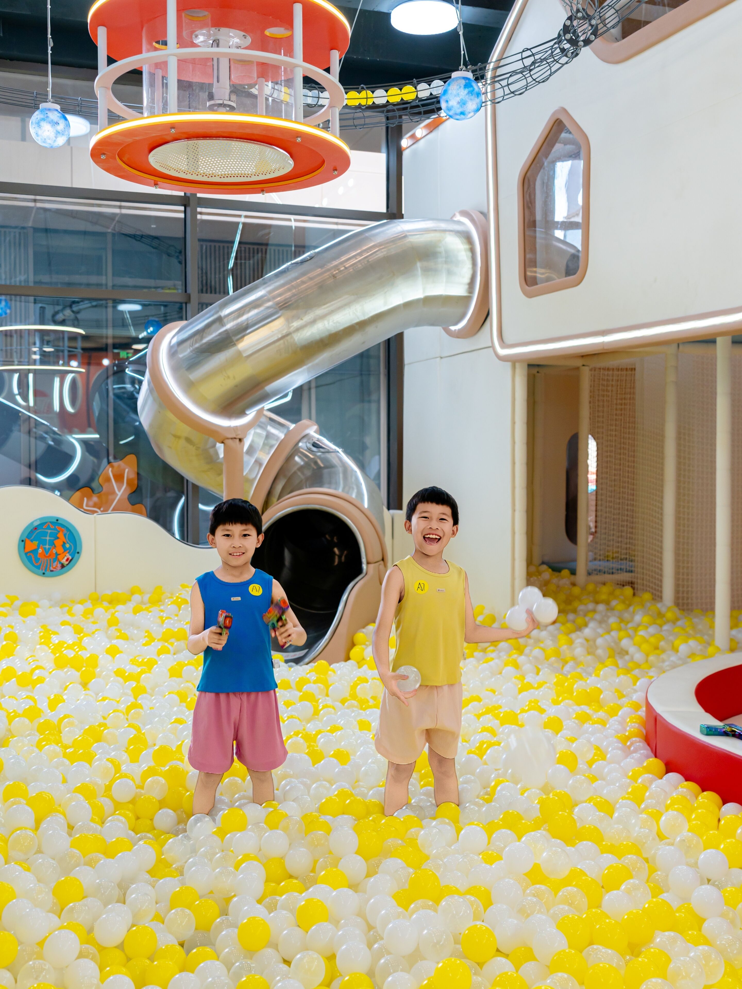 Ein Kinderspielbereich mit Bällebad, Rutsche und Spielhäuschen.